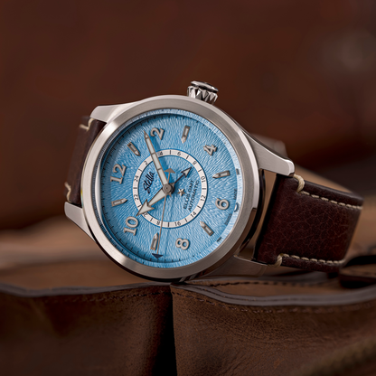 Watch with a blue face and brown leather strap on a brown background